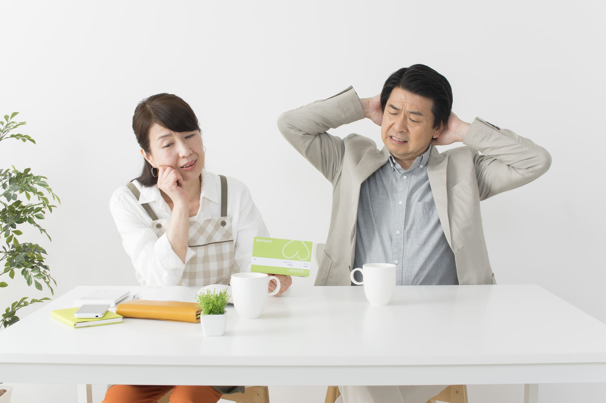 通帳を見ながら悩む夫婦