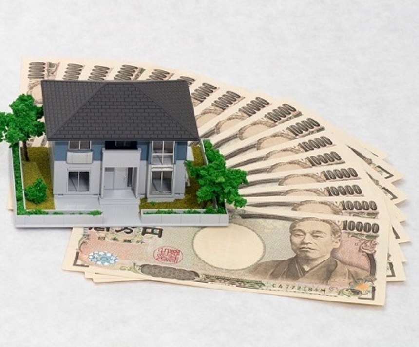 家の模型と電卓と一万円札